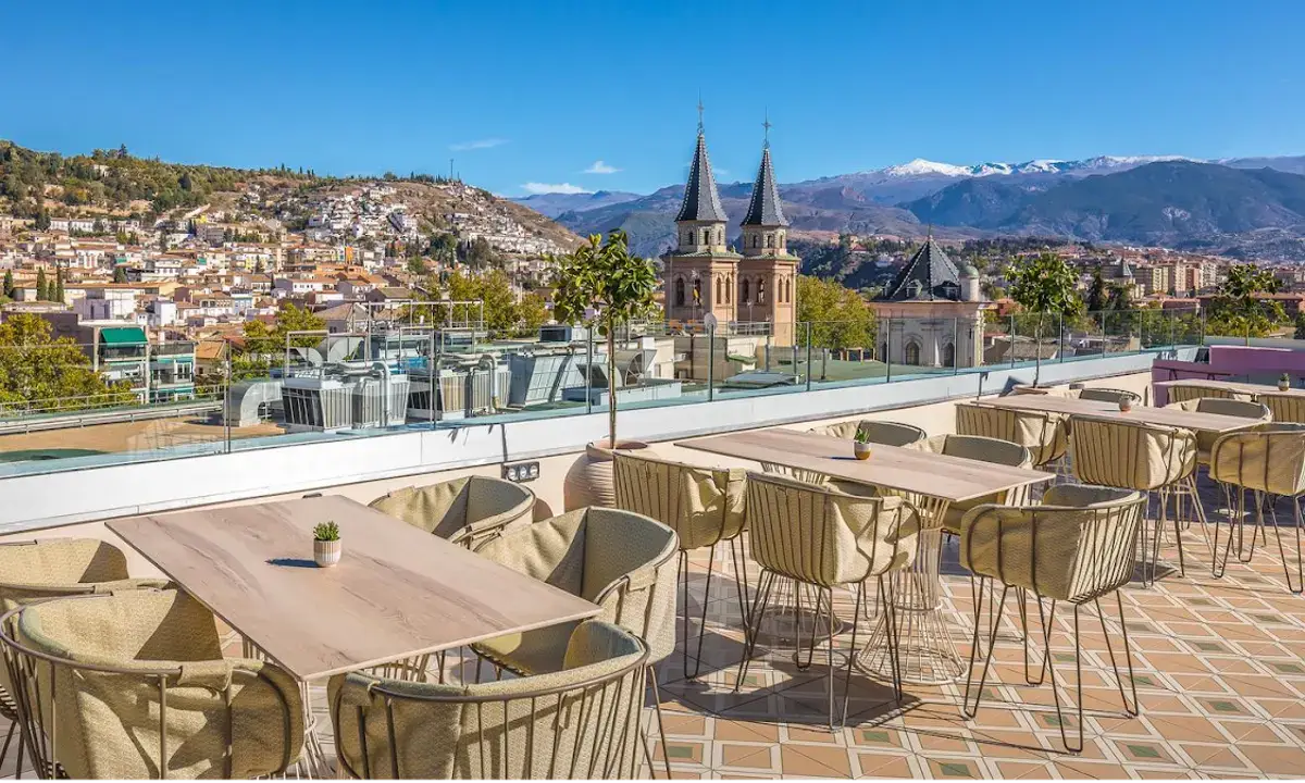 Rooftop terrace of B Heaven Granada bar with panoramic view of the Alhambra and Sierra Nevada at dusk