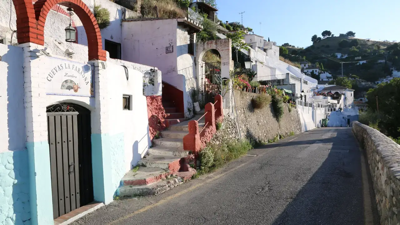 Whitewashed cave dwellings on Camino del Sacromonte above Granada with the Alhambra visible in the background